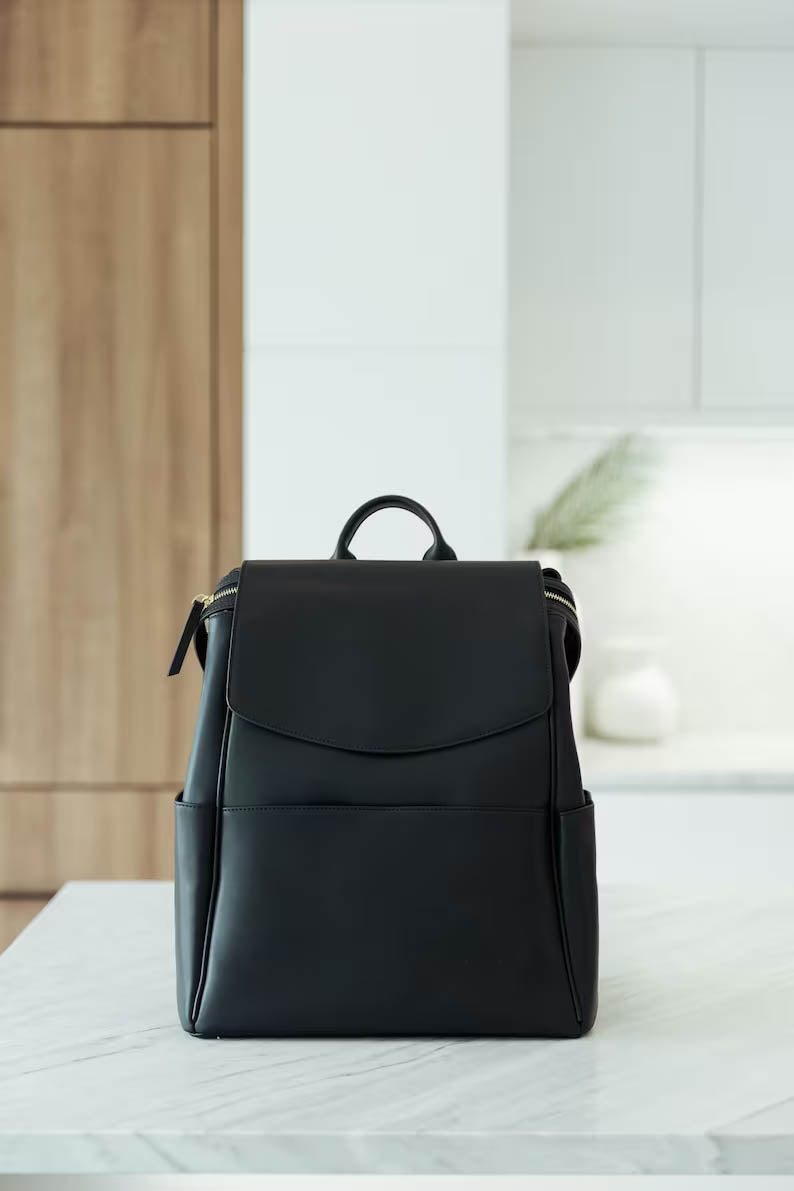 black leather changing backpack Peek-A-Boo Vegan Diaper Bag 2.0 in TWELVElittle Made with premium black leather this bag is perfect for both new mums and dads Black Leather Changing/Diaper Backpack (unisex)-