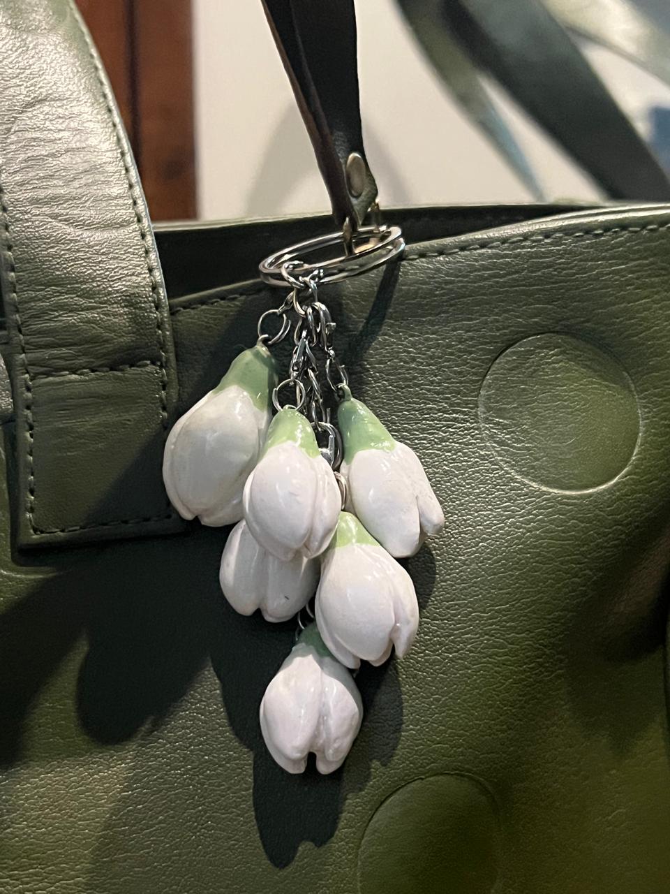 a closeup picture of ceramic bag charm white lillies
