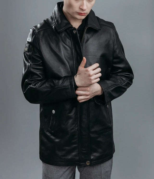 men wearin a premium leather jacket , high quality biker jacket standign against  a gray wall