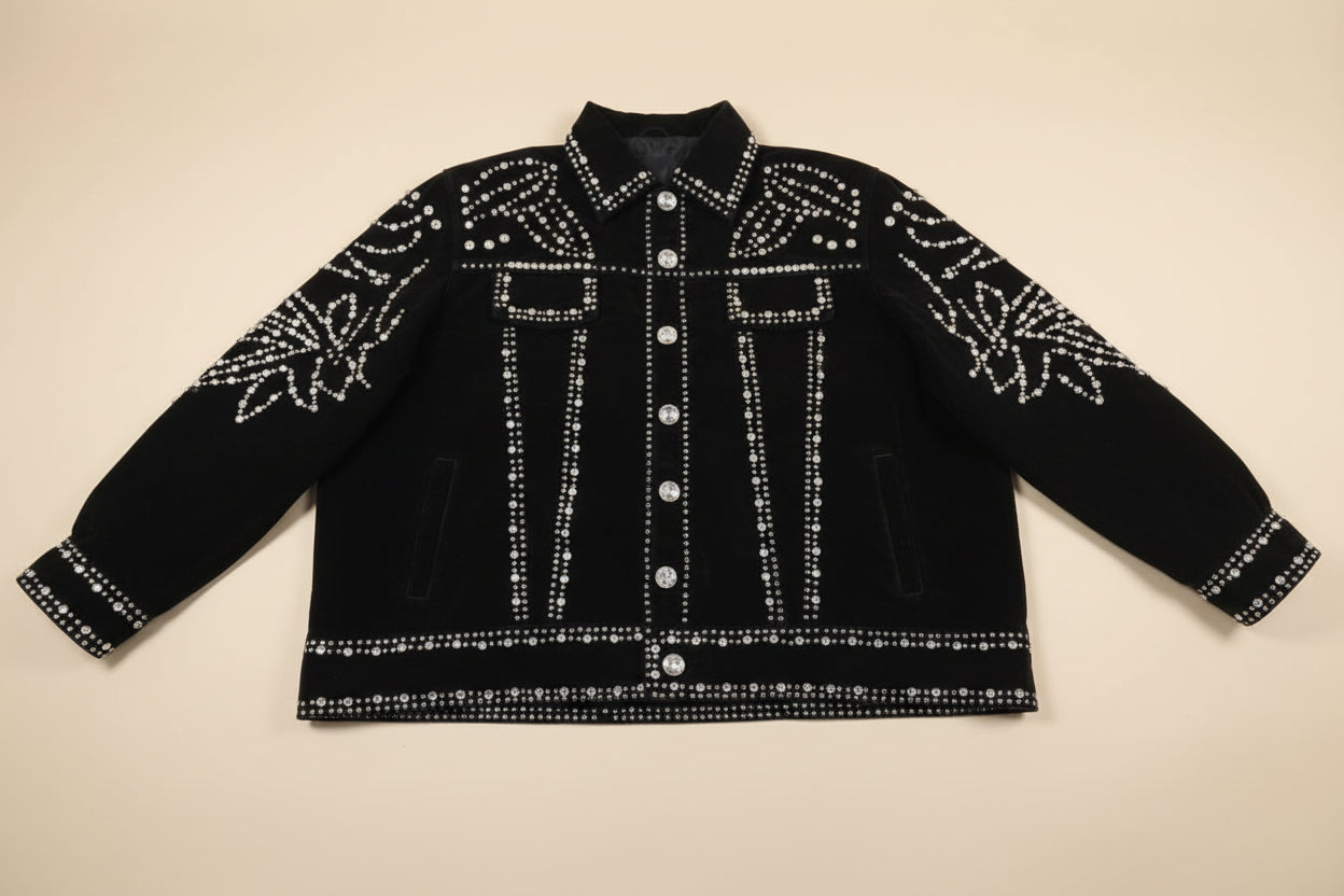 Black suede jacket with white rhinestone embellishments on a white sheet of paper.