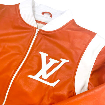 Close-up of Louis Vuitton orange bomber jacket with white accents on shoulders, white cuffs, collar and hem. White LV logo on left front chest 