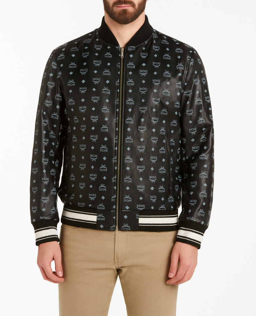 Man wearing a black MCM printed leather bomber jacket with beige pants on a white background