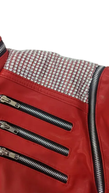 Red jacket with zippers and patterned collar on a textured white background