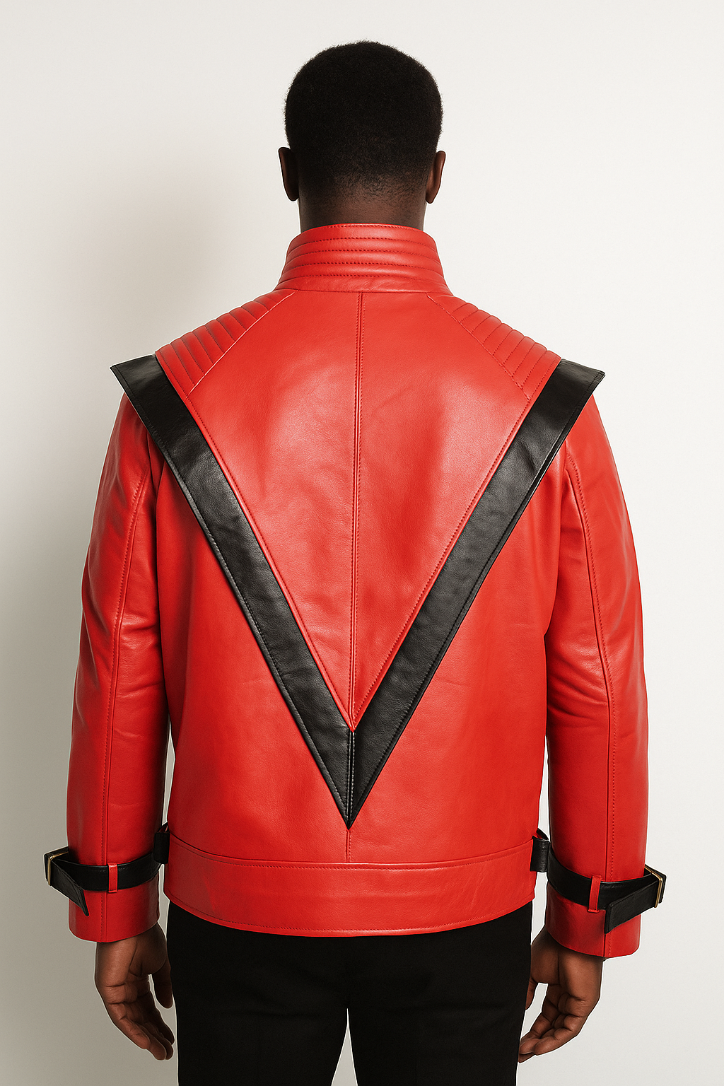 Handmade 80s-inspired Michael Jackson red leather jacket for men. Black American model wearing the jacket with black jeans, showing the backside of the jacket.  light gray background.