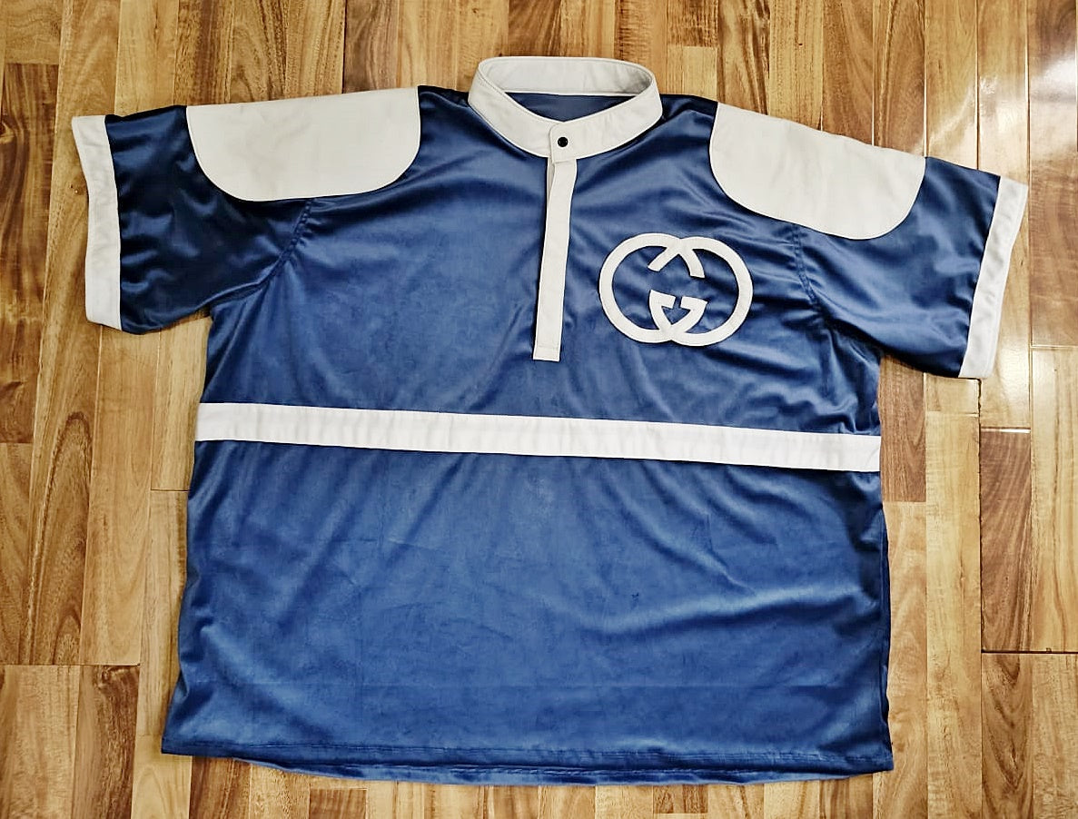 Blue velvet sports jersey with white accents on a wooden floor
