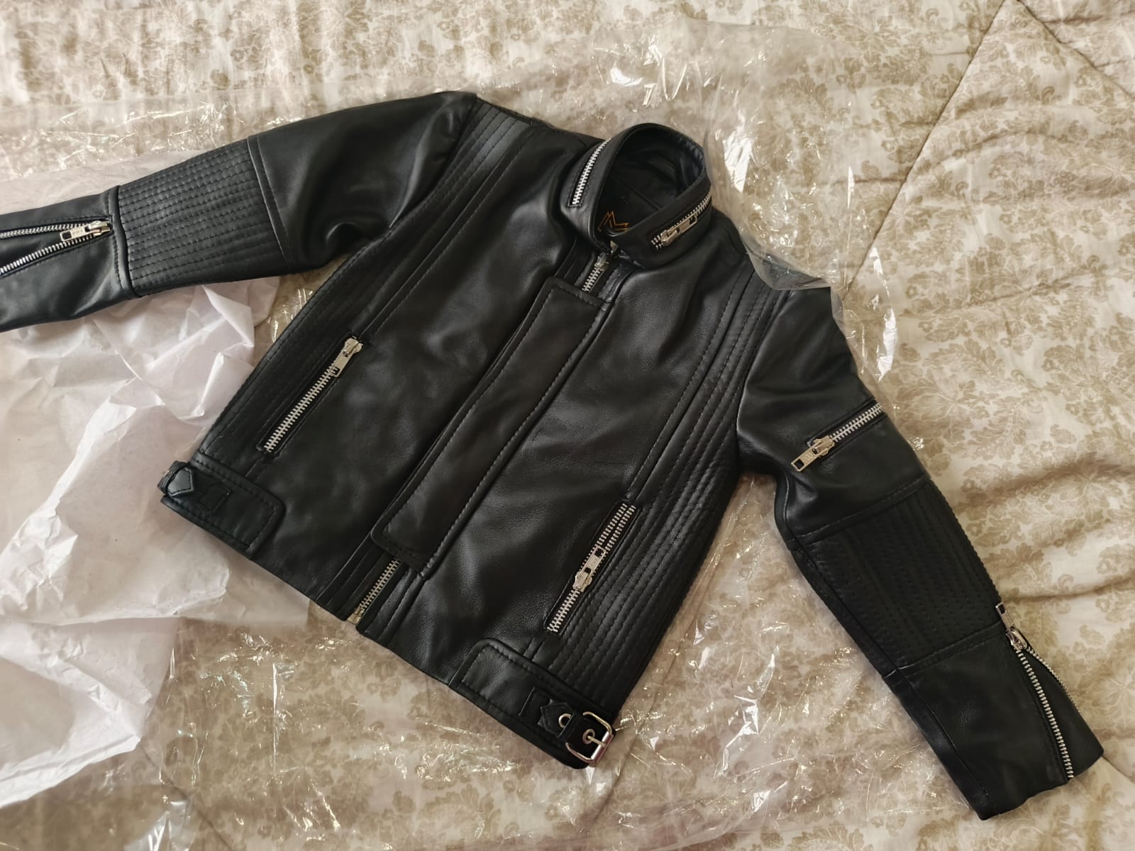 Black leather jacket with zippers on a textured surface