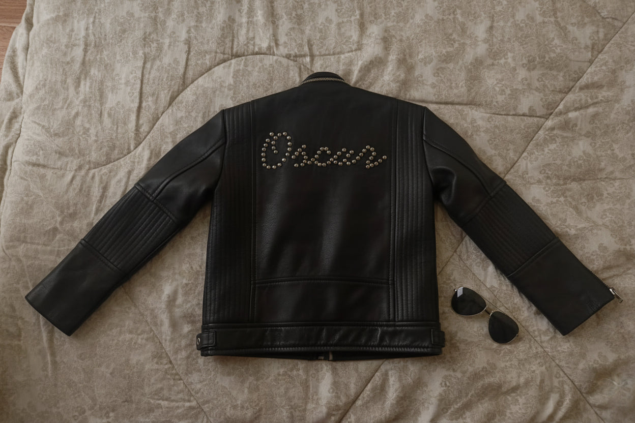 Black leather jacket with 'Oscar' embroidery on a textured surface
