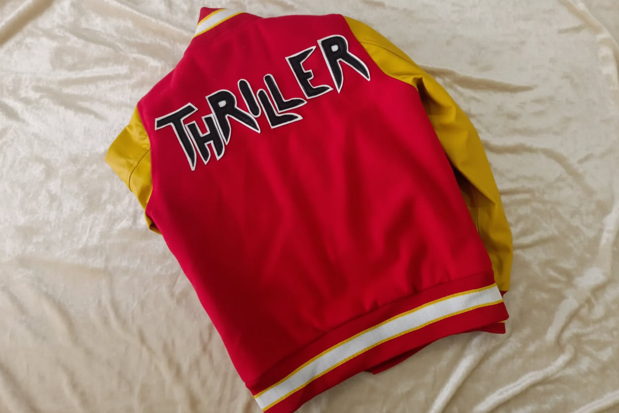 Red jacket with yellow sleeves and 'Thriller' text on a textured surface