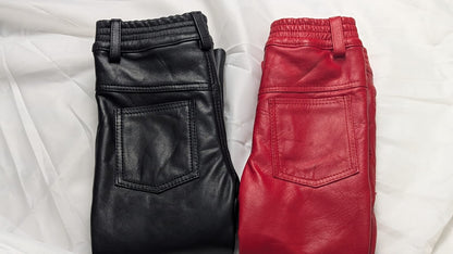 kid real leather pants folded and laid on a whtie silk fabric