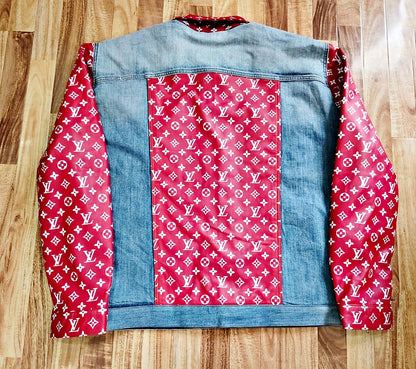 Denim jacket with white designer monogrammed pattern on red leather  on a wooden surface