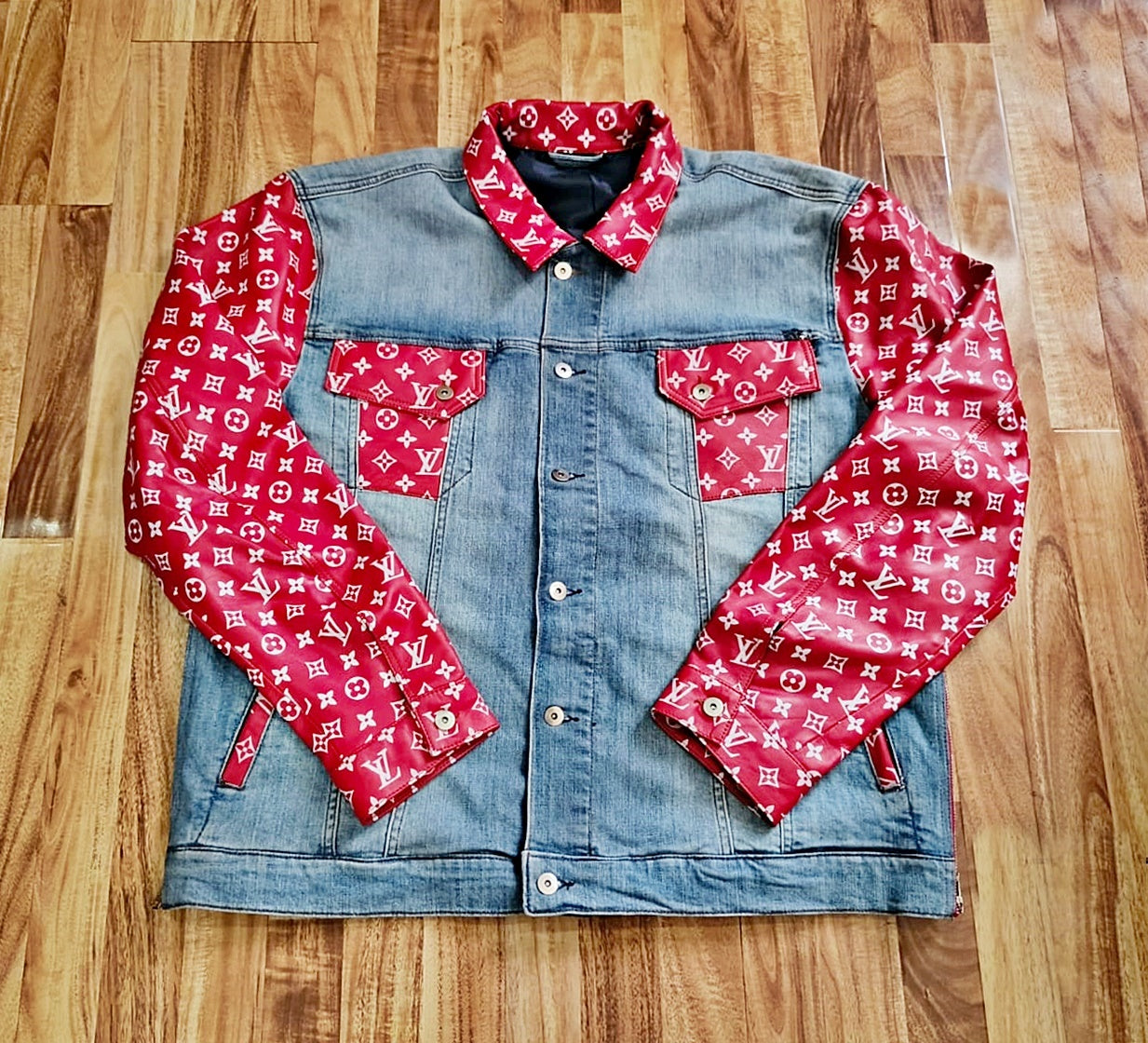 Trucker Denim jacket with white monogrammed on red leather on a wooden floor