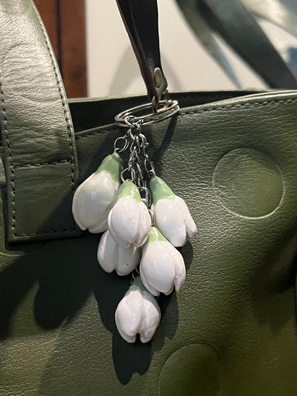 a closeup picture of ceramic bag charm white lillies 